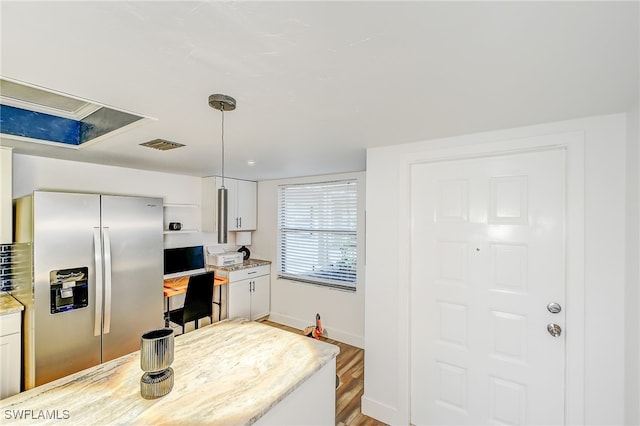 kitchen featuring white cabinetry, hanging light fixtures, stainless steel refrigerator with ice dispenser, and hardwood / wood-style flooring