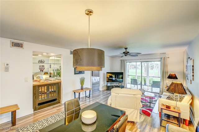 living room featuring wood-type flooring and ceiling fan