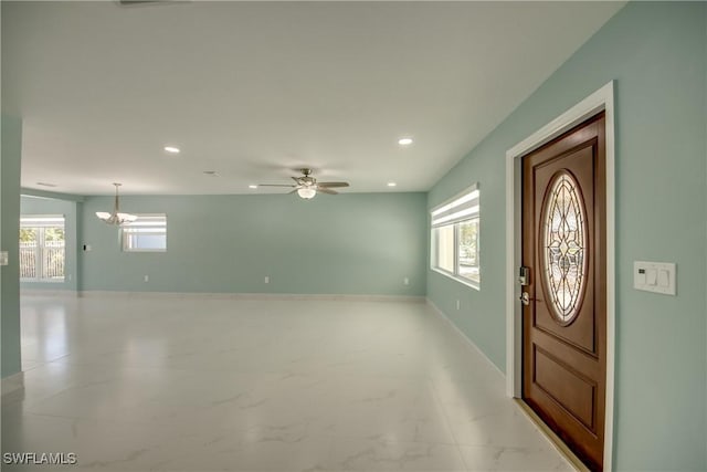 entrance foyer with ceiling fan with notable chandelier