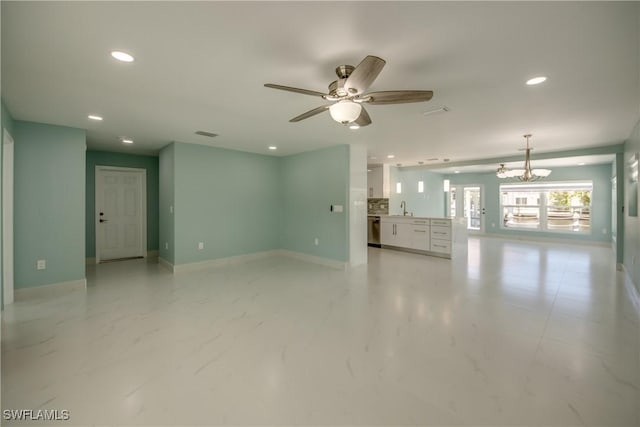 interior space featuring sink and ceiling fan with notable chandelier