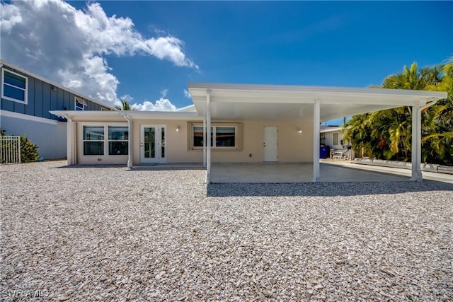 back of house featuring a carport