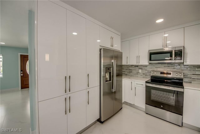 kitchen with white cabinets, decorative backsplash, and appliances with stainless steel finishes