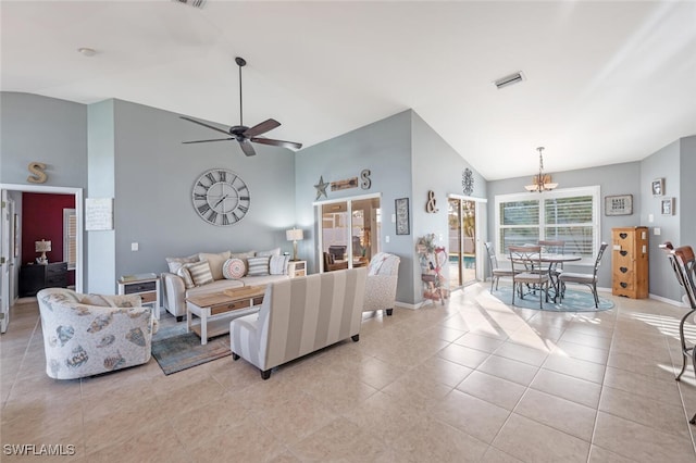 tiled living room featuring ceiling fan with notable chandelier and vaulted ceiling