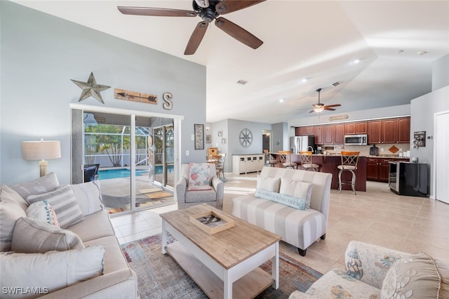 living room featuring ceiling fan, lofted ceiling, and light tile patterned floors