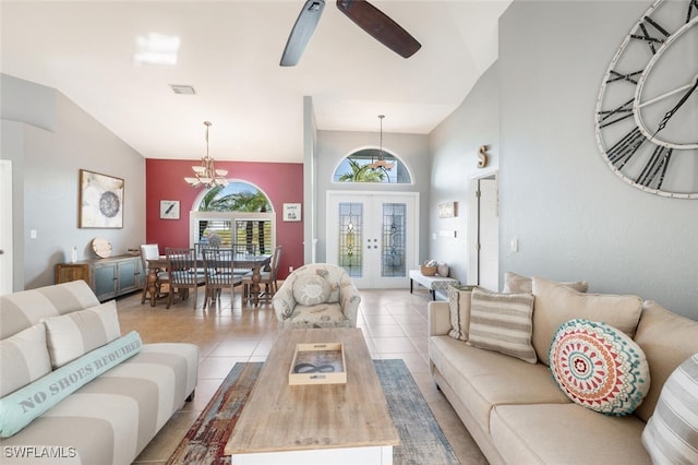 living room featuring ceiling fan with notable chandelier, french doors, light tile patterned floors, and lofted ceiling