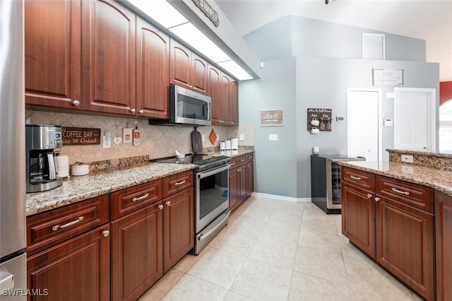 kitchen with wine cooler, appliances with stainless steel finishes, light tile patterned floors, light stone counters, and decorative backsplash