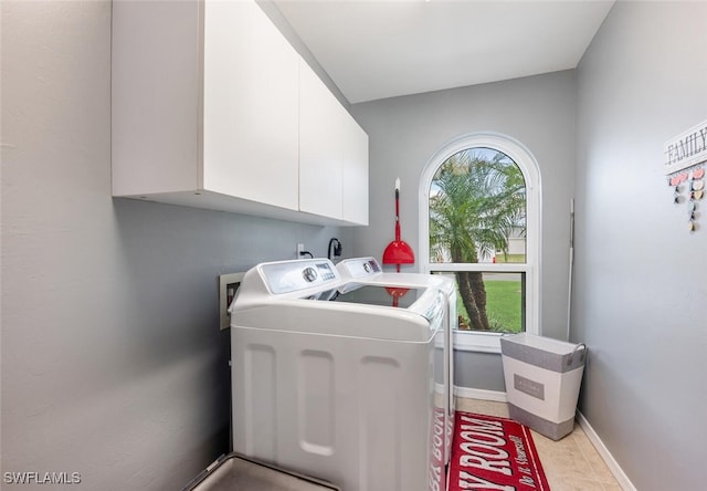 laundry room featuring washing machine and clothes dryer and cabinets