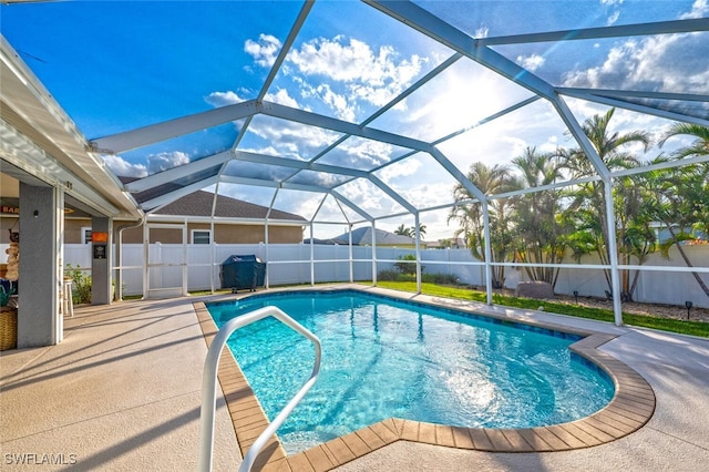 view of swimming pool featuring a grill, glass enclosure, and a patio area