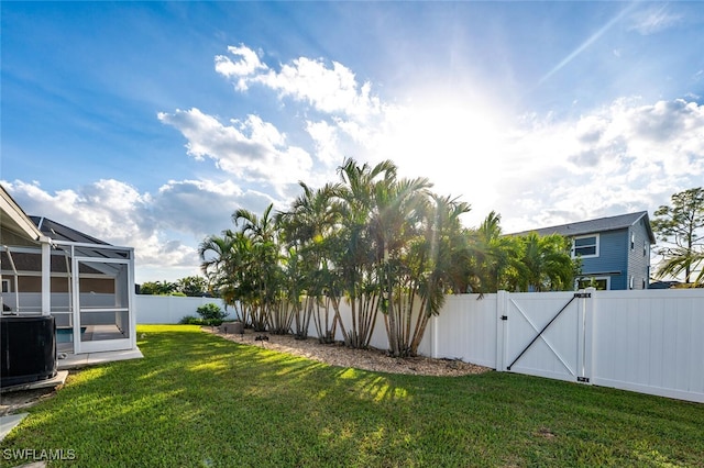 view of yard with a lanai and central air condition unit