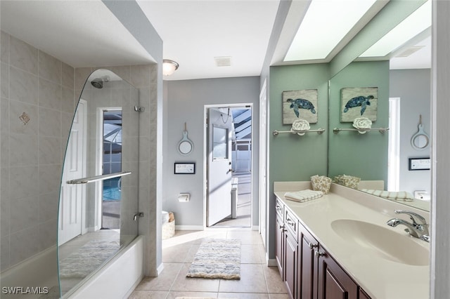 bathroom with tile patterned flooring, tiled shower / bath, and vanity