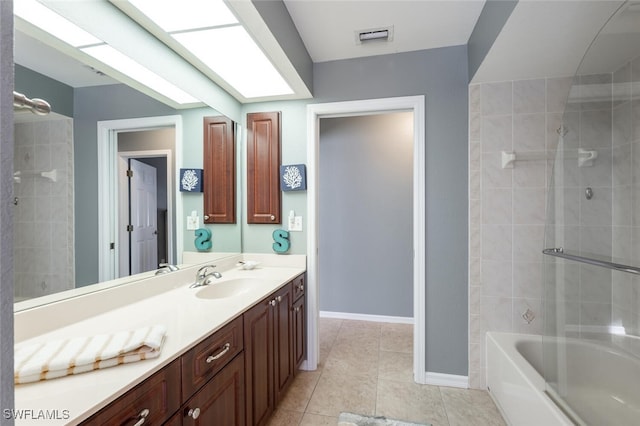 bathroom featuring vanity, tile patterned flooring, and tiled shower / bath