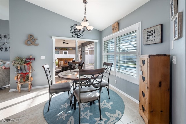 tiled dining area featuring lofted ceiling and ceiling fan with notable chandelier