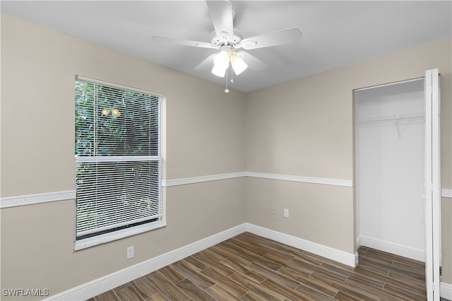 unfurnished bedroom with dark wood-type flooring, a closet, and ceiling fan