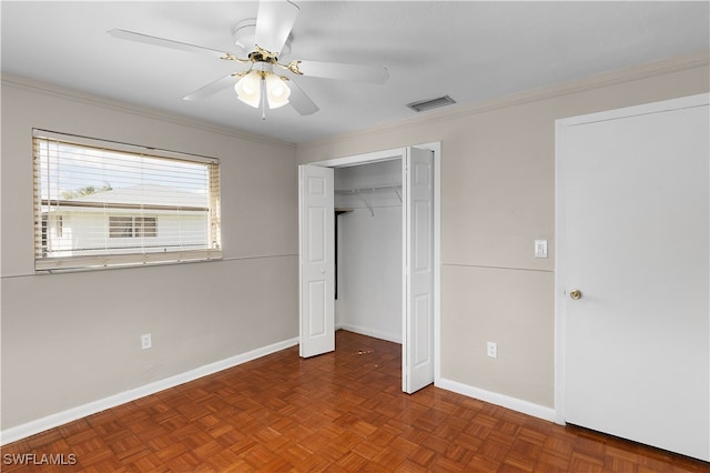 unfurnished bedroom with ornamental molding, a closet, dark parquet floors, and ceiling fan