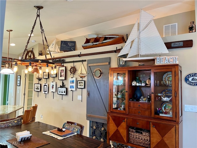 dining room with wood-type flooring and vaulted ceiling