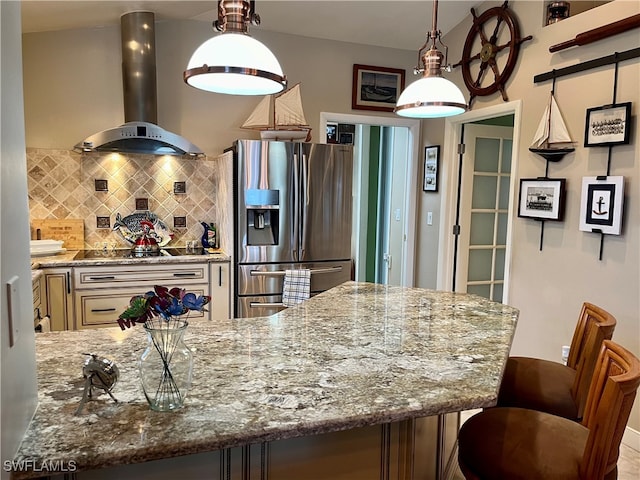 kitchen featuring decorative light fixtures, stainless steel fridge, decorative backsplash, and wall chimney range hood