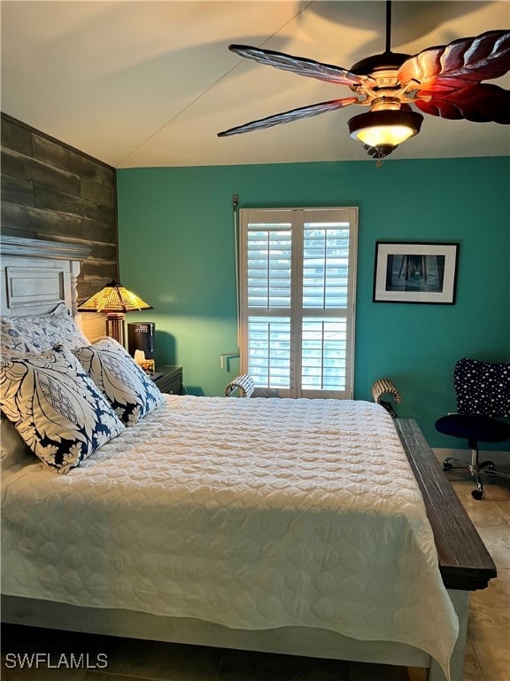 tiled bedroom featuring ceiling fan