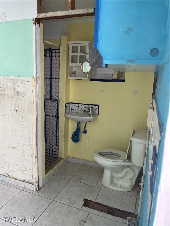 bathroom featuring tile patterned floors, toilet, and a shower with curtain