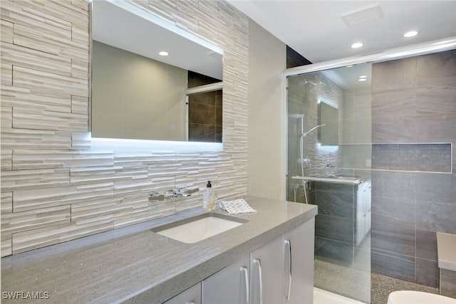 bathroom featuring walk in shower, vanity, tile walls, and toilet