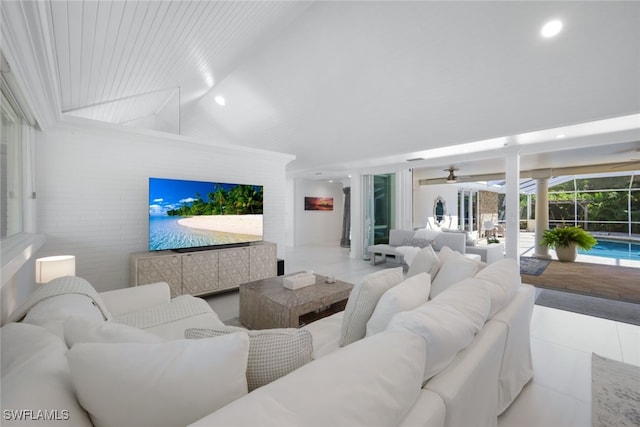 living room with tile patterned floors, ceiling fan, and lofted ceiling