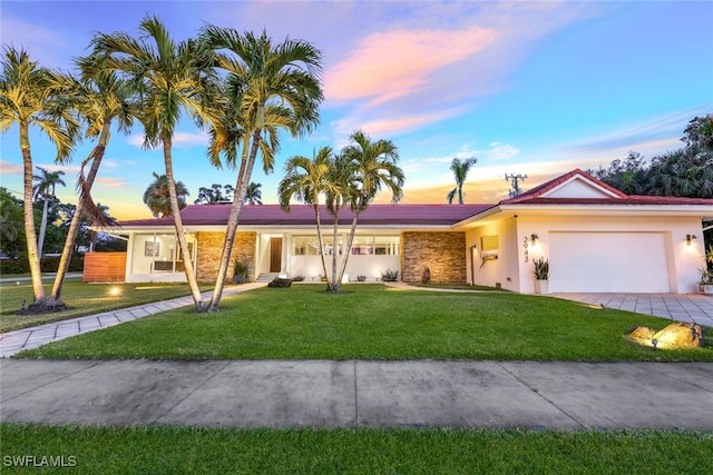 ranch-style house featuring a yard and a garage