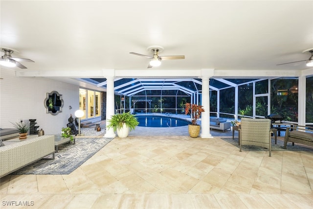 interior space with outdoor lounge area, glass enclosure, and ceiling fan