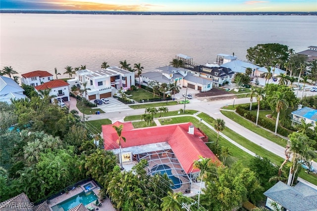 aerial view at dusk featuring a water view