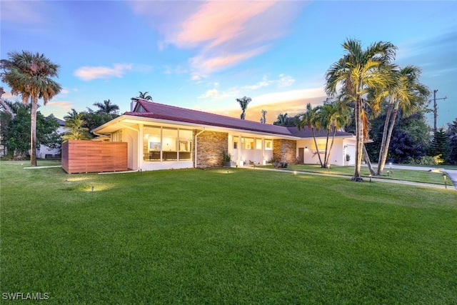 single story home featuring a lawn