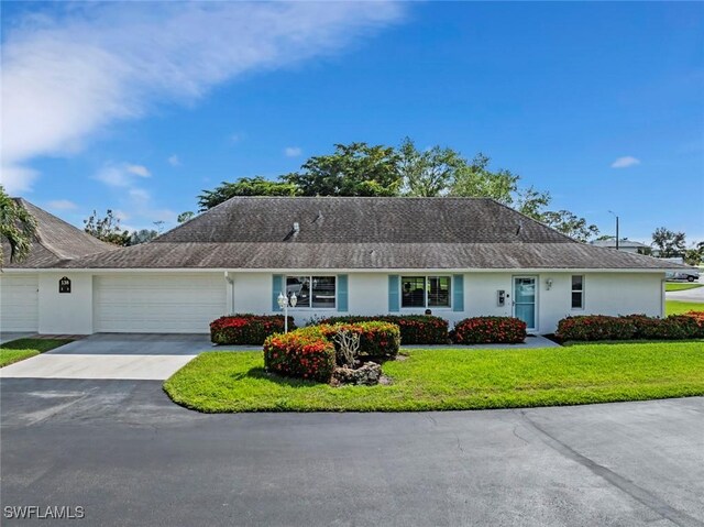 ranch-style home with a front yard and a garage