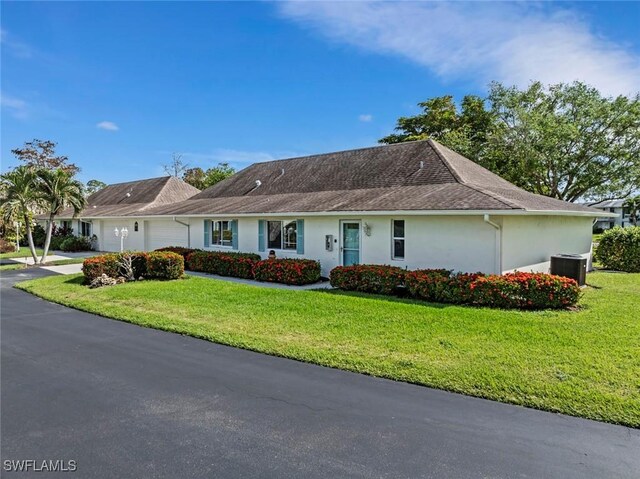 ranch-style house with central AC unit, a front lawn, and a garage