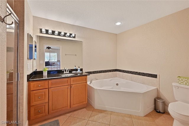 bathroom featuring tile patterned flooring, ceiling fan, vanity, a washtub, and toilet