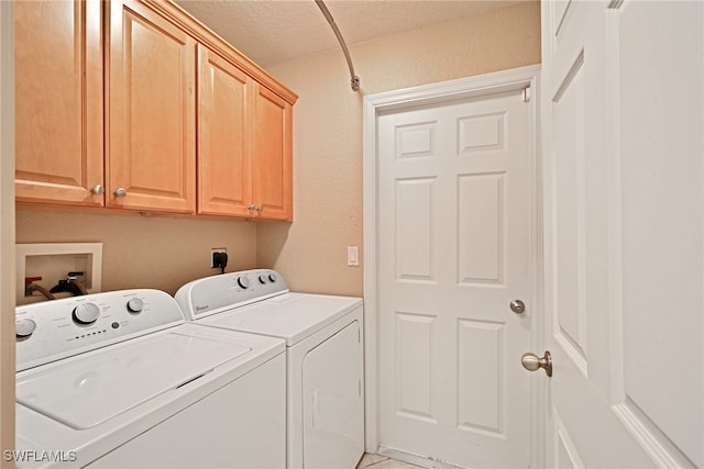 clothes washing area featuring cabinets, a textured ceiling, and separate washer and dryer