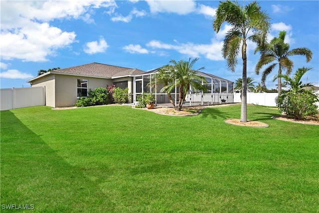 rear view of property with a yard and a lanai