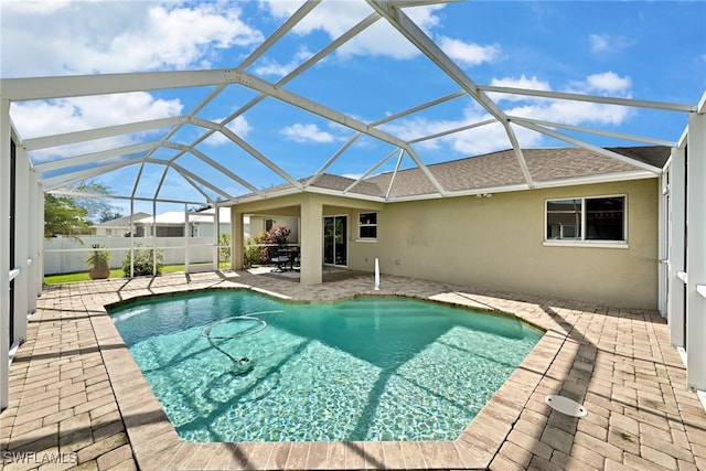 view of pool featuring glass enclosure and a patio area