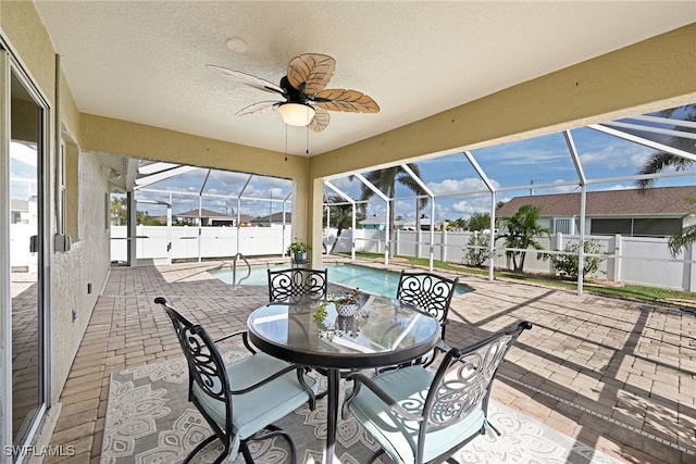 sunroom with ceiling fan and a pool