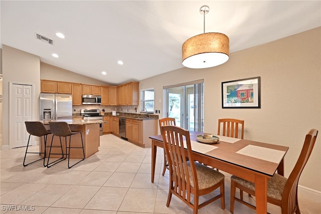 dining area with light tile patterned floors and vaulted ceiling