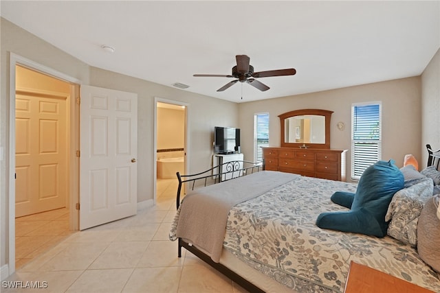 bedroom featuring connected bathroom, multiple windows, ceiling fan, and light tile patterned flooring