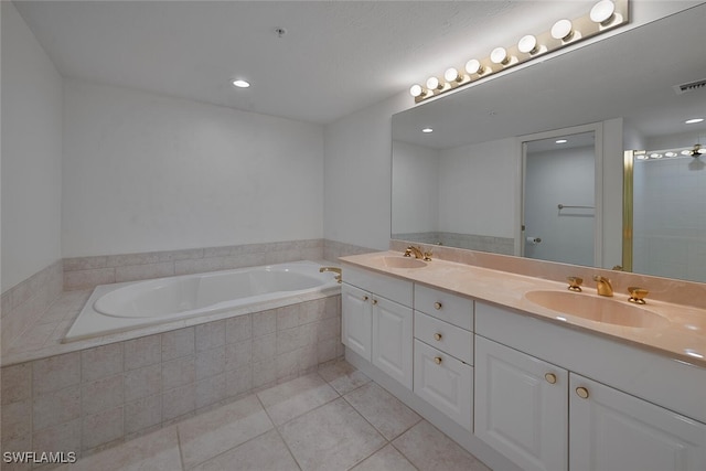 bathroom with tile patterned floors, tiled bath, and vanity