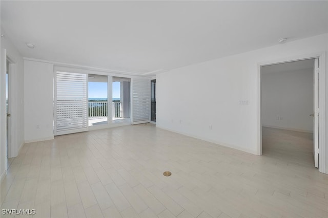 empty room with a water view and light wood-type flooring