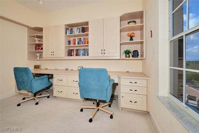 office space with light colored carpet and built in desk