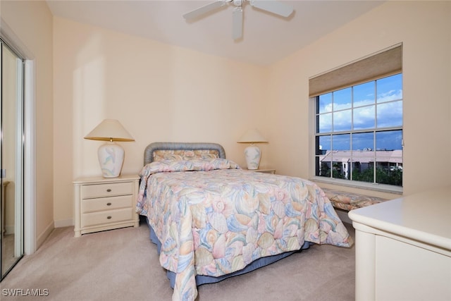 carpeted bedroom with ceiling fan and a closet