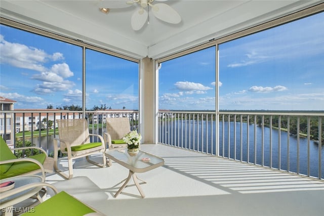 unfurnished sunroom with a water view and ceiling fan