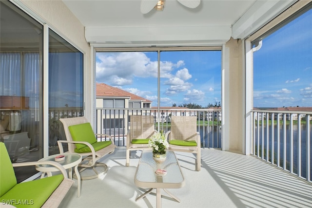 sunroom / solarium with a water view and ceiling fan