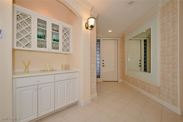 hall with light tile patterned flooring and crown molding