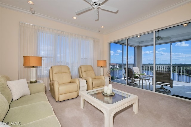 living room with ceiling fan, light carpet, a water view, and crown molding