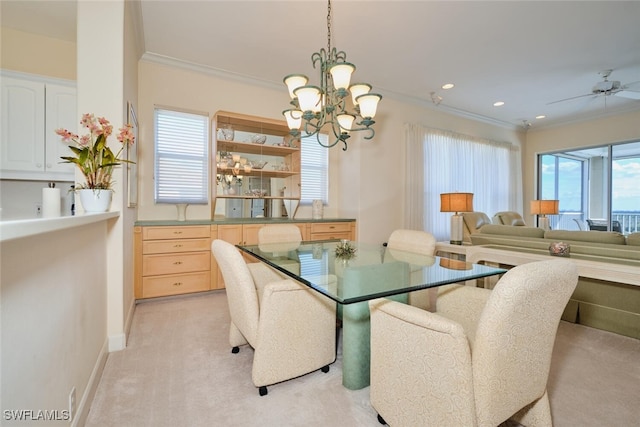 carpeted dining space with ceiling fan with notable chandelier and crown molding