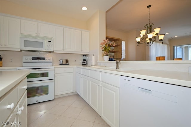 kitchen with a chandelier, white cabinetry, white appliances, and pendant lighting