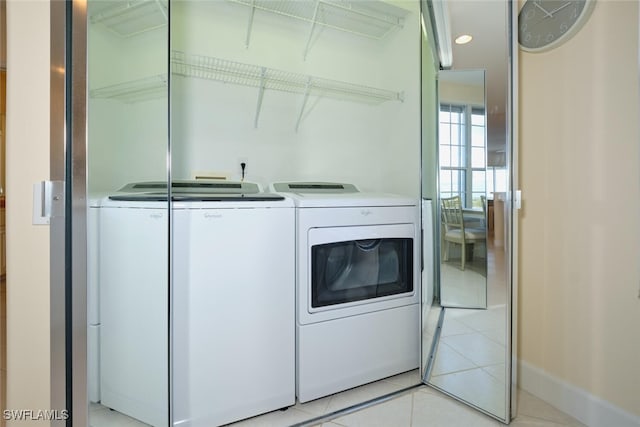 laundry area featuring separate washer and dryer and light tile patterned floors