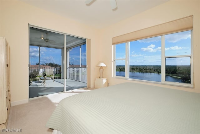 bedroom with access to outside, light colored carpet, a water view, and ceiling fan