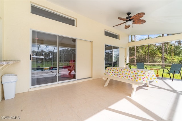 sunroom with ceiling fan and vaulted ceiling